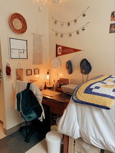 a room with a bed, desk and hanging decorations on the wall next to it