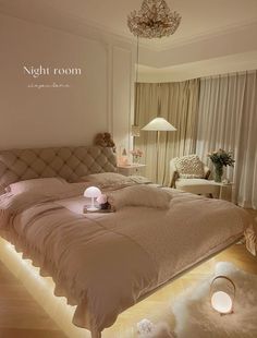 a bedroom with a large bed and lights on the floor in front of it's headboard