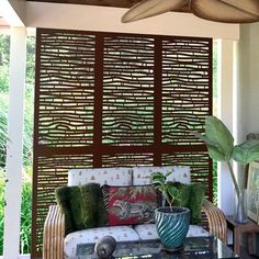 a living room with a ceiling fan and couches on the outside patio area in front of it