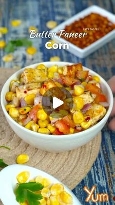 a bowl filled with corn next to another bowl full of food