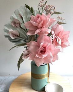 pink flowers are in a vase on a table