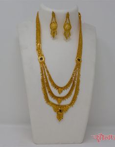 a gold necklace and earring set on a mannequin