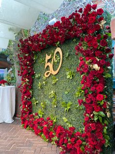 the sign is covered with red flowers and greenery