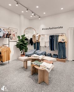 the inside of a clothing store with clothes on display