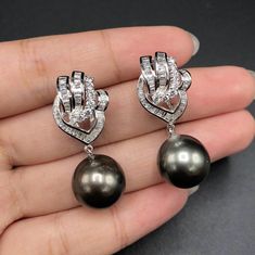 EXTREMELY LUXURIOUS, AUTHENTIC TAHITIAN PEARLS! Perfect for ANY FORMAL occasion! We are presenting you A PAIR OF matching TAHITIAN PEARLS with LUSTROUS BLACK color. SET IN HANDCRAFTED, 18K SOLID GOLD DROP EARRINGS WITH SPECIAL, SECURED OMEGA BACKINGS. ACCENTED WITH SUPER SPARKLING, WHITE AND CLEAR 108 F/VS, GENUINE DIAMONDS WEIGHTING A TOTAL OF 1.74 CARATS! Extremely elegant and tasteful! The pearls are so lustrous and shiny! The design is chic and elegant. Clean and classy! IN CASE OF RETURN FO Luxury Tahitian Pearl Round Earrings, Luxury Gray Jewelry For Formal Occasions, Gray Luxury Jewelry For Formal Occasions, Elegant Gray Earrings For Wedding, Elegant Gray Jewelry For Evening, Indian Jewellery Design Earrings, Cocktail Wedding, Jewelry Design Earrings, Design Earrings