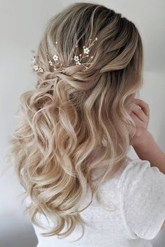 the back of a woman's head with long blonde hair and flowers in her hair