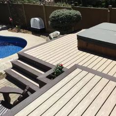 a hot tub sitting on top of a wooden deck next to a swimming pool