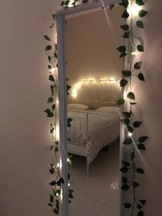 a mirror that has some plants growing on it and lights in front of the mirror