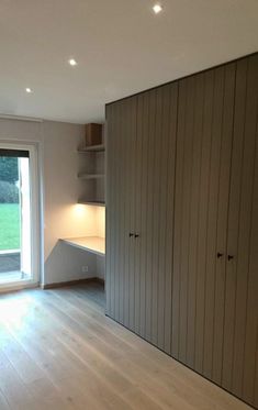 an empty room with wooden floors and sliding doors