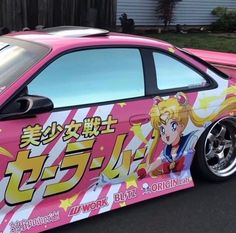 a pink car with an anime theme painted on it's side in front of a house