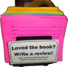 a stack of books with a sign that says loved the book? write a review