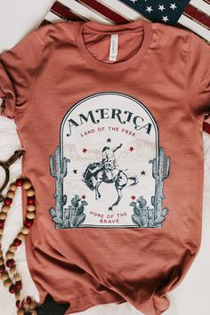 "🇺🇸 Land of The Free because of The Brave 🇺🇸 This shirt is high quality and super comfy!  This is definitely a shirt that you need to add to your wardrobe. Tag us in a photo of you wearing our shirt on Instagram @wildthreadsandco !  Please allow 2-3 days for printing 🌵CARE INSTRUCTIONS 🌵 For the longest lifespan for your Wild Threads + Co. shirt, we recommend turning your tee inside out, washing with cool water and hanging them to dry. We advise you to not use bleach. ⚡️ SIZING ⚡️ Measurem Women's Graphic Tees, Cute Country Outfits, Rodeo Shirts, Western Style Outfits, Fourth Of July Shirts, Patriotic Shirt, Land Of The Free, Vinyl Shirts, Country Shirts