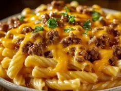 a close up of a plate of macaroni and cheese with meat on it