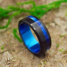 a black and blue ring sitting on the ground