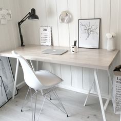 a white desk with a laptop on top of it next to a lamp and pictures