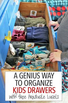 a woman standing in front of a blue drawer filled with children's clothing and other items