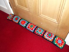 a red carpeted floor next to a wooden door with a decorative object on it