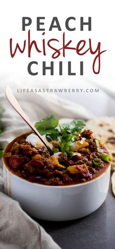 a white bowl filled with chili next to pita bread