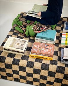 there are many books on the table and one person is sitting down with them reading