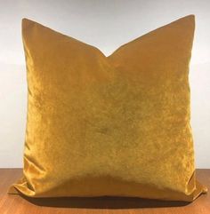 a yellow pillow sitting on top of a wooden table