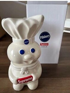 a white ceramic figurine with blue eyes and a chef's hat on it