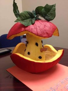 a fruit sculpture made to look like an apple with a leaf on it's top