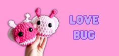 two crocheted bugs are held up in front of a pink background with the words love bug on it