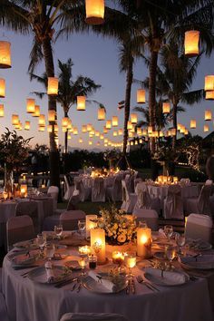 an image of a table set up for a wedding with candles and paper lanterns in the background