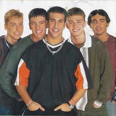 a group of young men standing next to each other in front of a white background