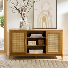 a wooden entertainment center with a bowl on top and books in front of the cabinet