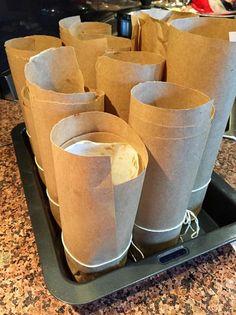 several brown paper cups sitting on top of a black tray next to a countertop