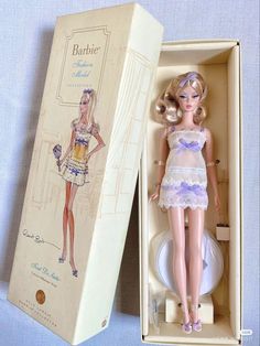 a barbie doll in a box with the lid open