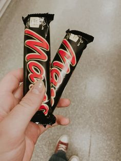 a person holding two chocolate bars in their hand