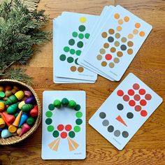 four matching cards on a table with a basket of crayons and pine branches