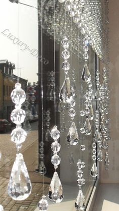 some crystal beads hanging from the side of a window