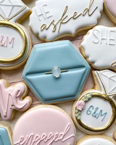 decorated cookies with wedding rings and engagement ring on them, all in pastel colors