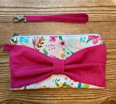 Great for those casual nights out with this beautiful watercolor design wristlet clutch purse with pink interior lining. Added details with a pink bow on one side and a silver heart zipper pull gives it a fun look. Makes a beautiful and memorable gift.  This wristlet clutch can fit your cell phone, credit cards, car keys, and other essentials. The wristlet clutch purse has a detachable wristlet strap and measures 10"wide by 5.75" length. Purse is shipped first class USPS carefully wrapped with w Floral Clutches, Wristlet Purse, Pink Interior, Wristlet Clutch, Beautiful Watercolor, Wristlet Wallet, Watercolor Design, Car Keys, Memorable Gifts