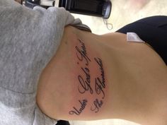 a woman with a tattoo on her stomach that says, under god's arms be fearless