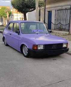 a purple car parked in front of a building