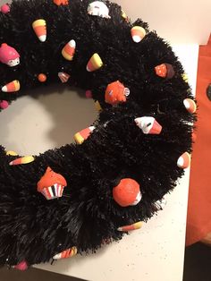 a black wreath with candy decorations on it