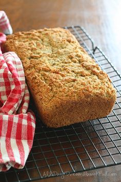 a loaf of bread sitting on top of a cooling rack next to a red and white towel