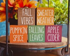 wooden blocks that say fall vibes weather, pumpkin falling apple cider and spice leaves cider