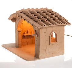 a clay model of a small house with an oven on the outside and brick roof