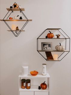 two shelves with pumpkins, candles and other items on them in the shape of hexagonal shapes