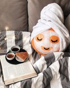 a towel wrapped around a pillow with eyes drawn on it next to a cup of coffee and an open book