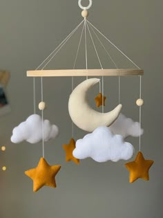 a mobile with stars, moon and clouds hanging from it's sides in the sky