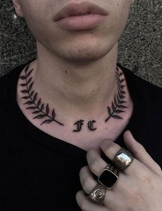 a man with a tattoo on his neck is holding his hand up to his chest