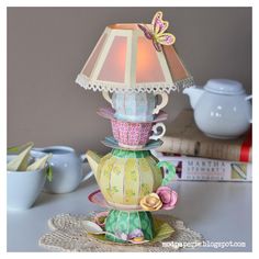 a lamp that is sitting on top of a table next to a cup and saucer