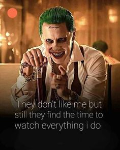 the joker with green hair and piercings is holding an umbrella in his right hand