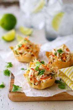 small appetizers on a cutting board with lemons and cilantro in the background